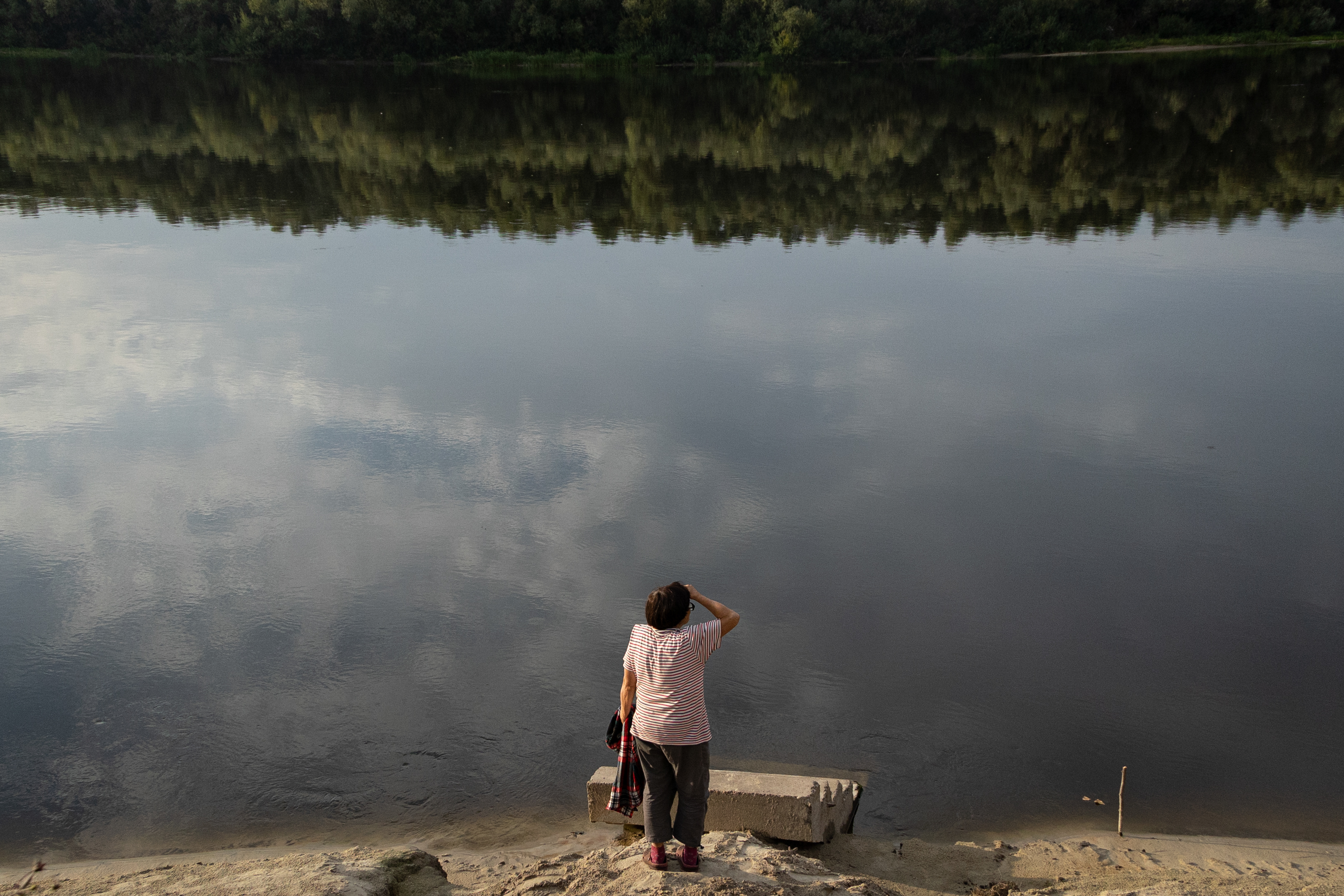 Eine Anwohnerin im Dorf Ladynka, Oblast Tschernihiw, schaut auf den verschmutzten Fluss Desna, Foto © Danylo Dubtschak/Frontliner 